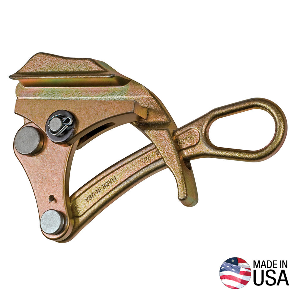 Gold-colored metal cable grip clamp with a loop handle and spring-loaded jaw mechanism, shown isolated on a light gray background. The industrial tool has a textured metal finish, visible pivot pins, and stamped “Made in USA” markings. A small U.S. flag icon with the text “MADE IN USA” appears in the lower-right corner.
