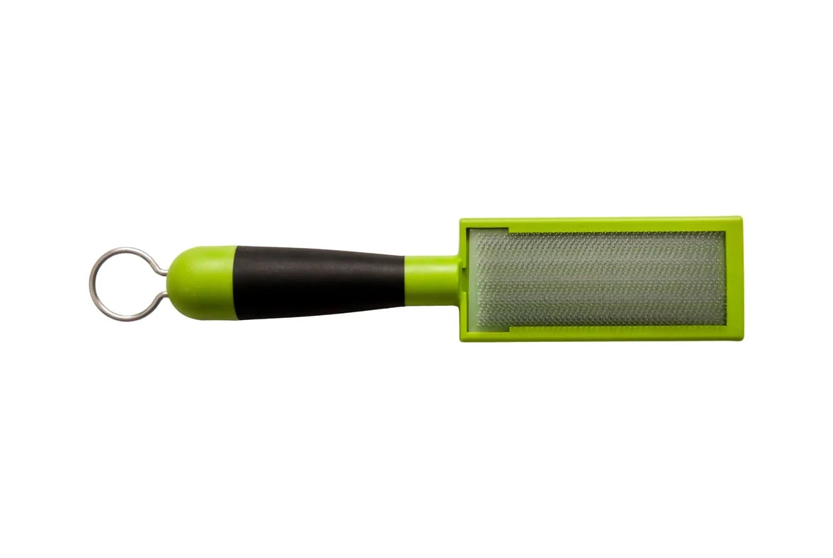 Handheld wire-mesh cleaning tool displayed horizontally on a light gray background. The tool features a rectangular metal mesh cleaning surface set within a bright green plastic frame. A black-and-green ergonomic handle extends from the frame and ends in a metal hanging loop for storage. The compact tool is designed for scraping or cleaning debris from surfaces, with the textured mesh panel prominently visible.