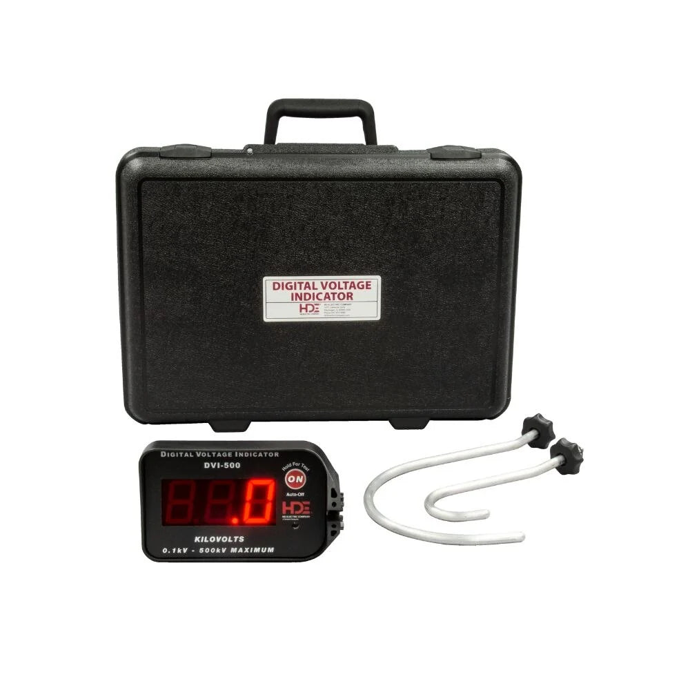 Digital voltage indicator kit consisting of a black hard carrying case labeled “Digital Voltage Indicator,” a handheld digital display unit with an illuminated red numeric readout, and a pair of curved metal test probes. The electrical testing equipment is arranged on a light gray background.