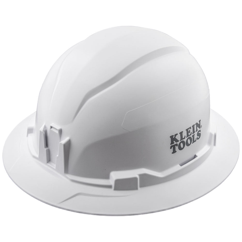 White Klein Tools hard hat shown in a three-quarter front view against a light gray background. The hard hat features a full brim, a smooth molded shell with raised ridges along the top, and accessory mounting slots around the sides. The black “KLEIN TOOLS” logo is printed on the right side of the helmet.