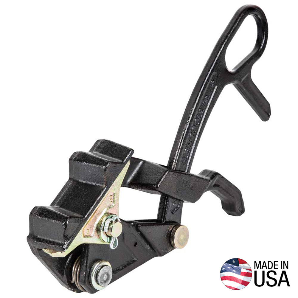 Black metal cable grip pulling tool with a hooked handle and hinged clamping jaws, shown against a light gray background. The tool features multiple pivot points, rollers, and fastening hardware designed to securely grip wire or cable during pulling operations. A “MADE IN USA” badge with an American flag graphic appears in the lower-right corner of the image.