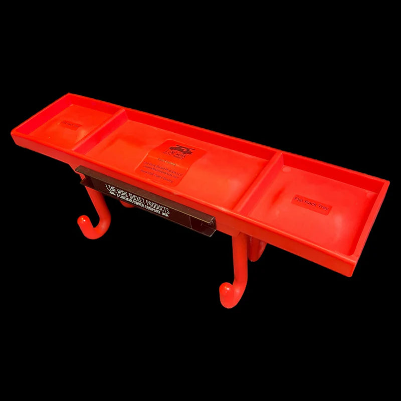 Bright orange utility rack tray with three divided storage compartments and two integrated hanging hooks underneath, displayed against a black background. The tray is mounted on a dark metal support bracket labeled “Line Work Basket Products,” with visible product labels inside the compartments. Designed for organizing tools, hardware, or small parts on a work basket or utility vehicle.