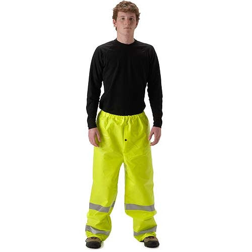 Person standing facing forward against a plain white background, wearing a black long-sleeve shirt, fluorescent yellow high-visibility rain pants with reflective bands around the lower legs, and dark work boots. The full-body product-style image clearly shows the loose-fit waterproof pants.