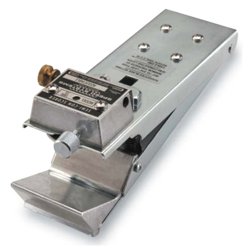 A stainless steel mechanical device, likely a metal detector or electronic sensor module, with a stamped metal body, a small brass screw, and a knurled adjustment knob, shown on a white background.
